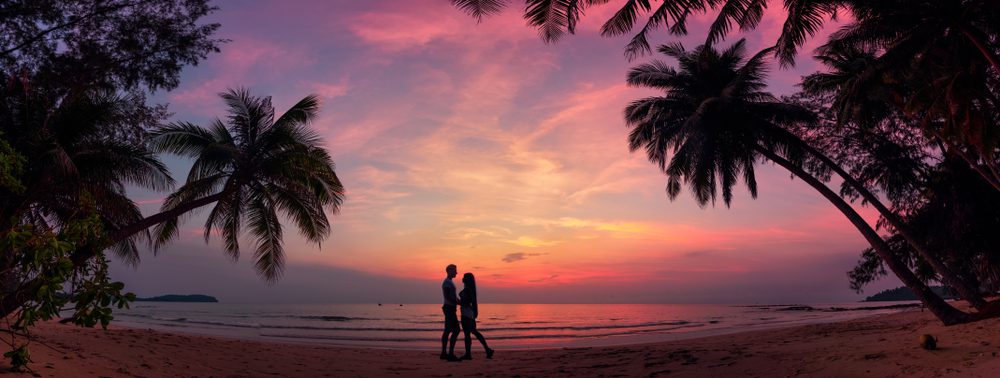 Romantic,Couple,On,The,Tropical,Beach,At,Background,Colorful,Sunset